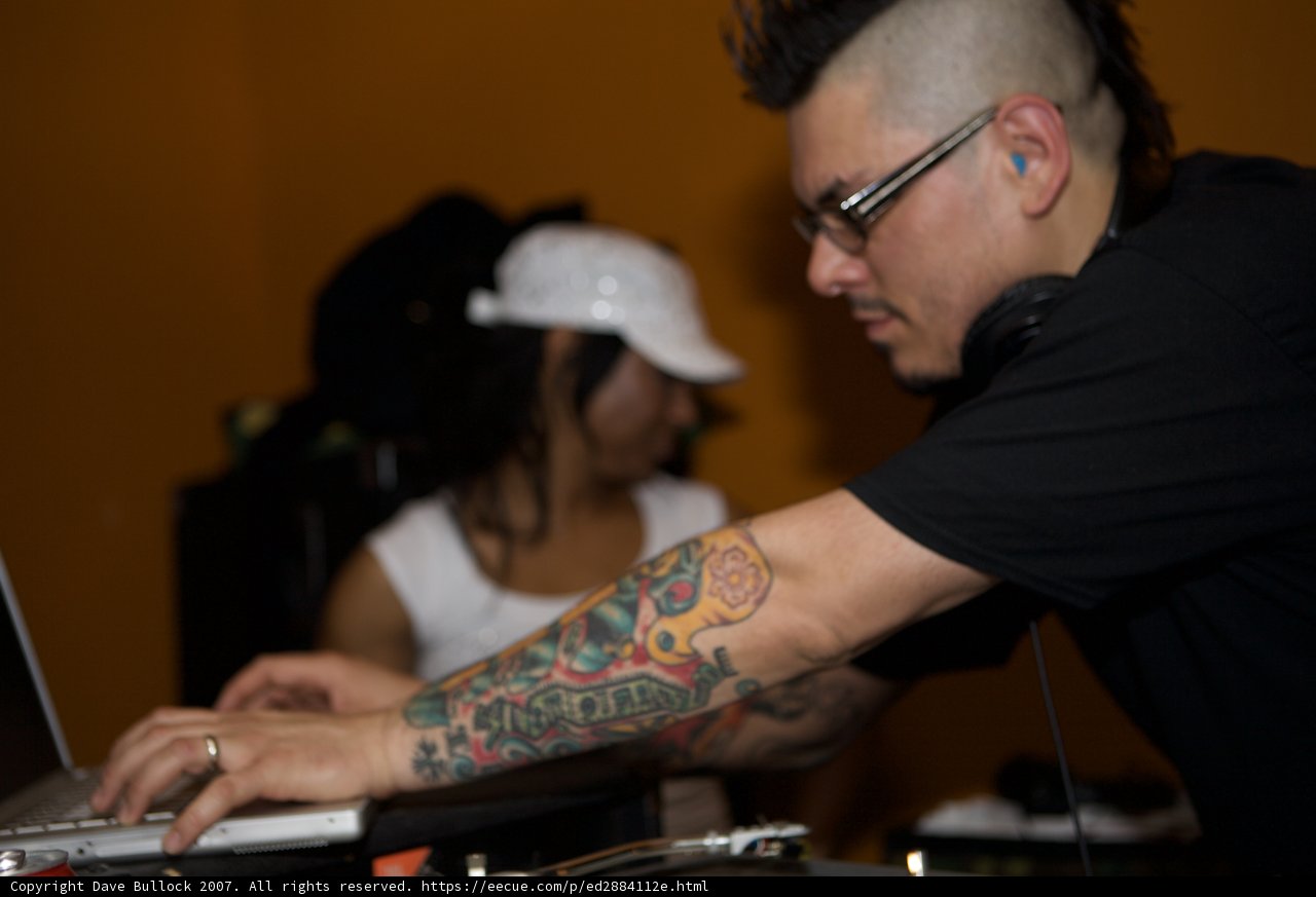 Black Shirted Deejay Flaunting Tattoos and Headphones