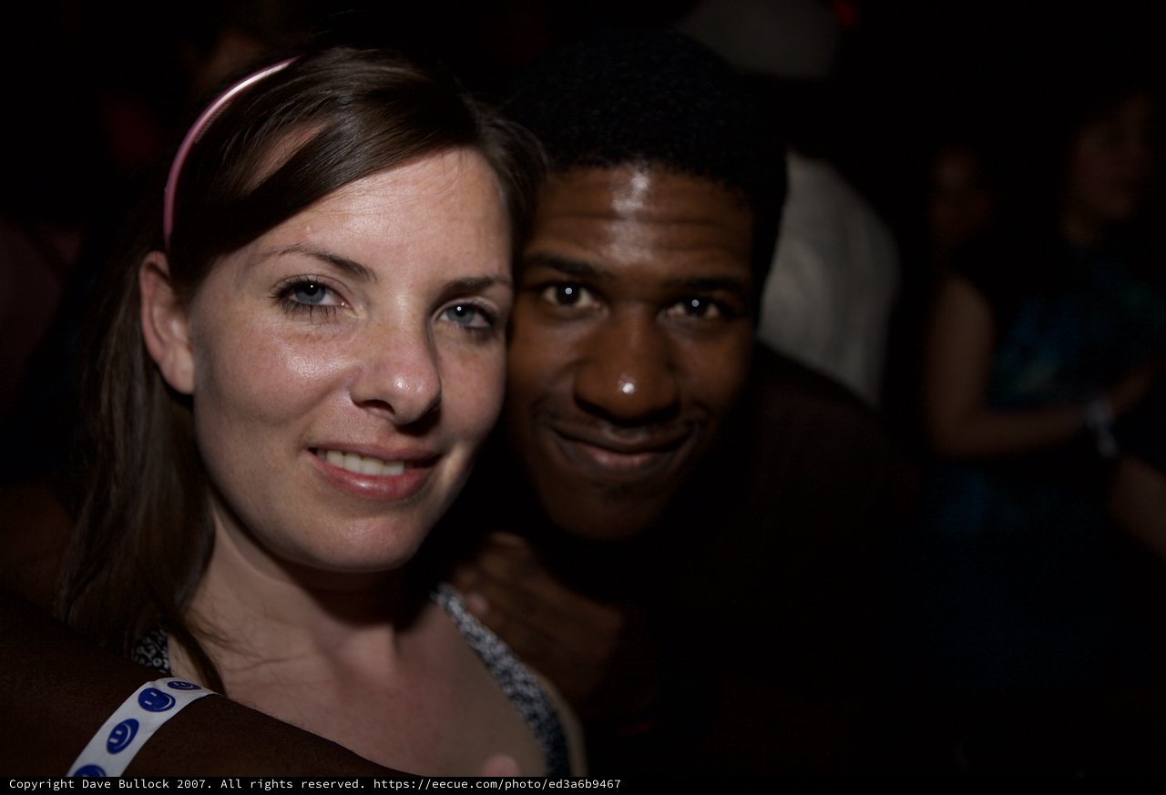 Two Friends Smiling Together at a Nighttime Event