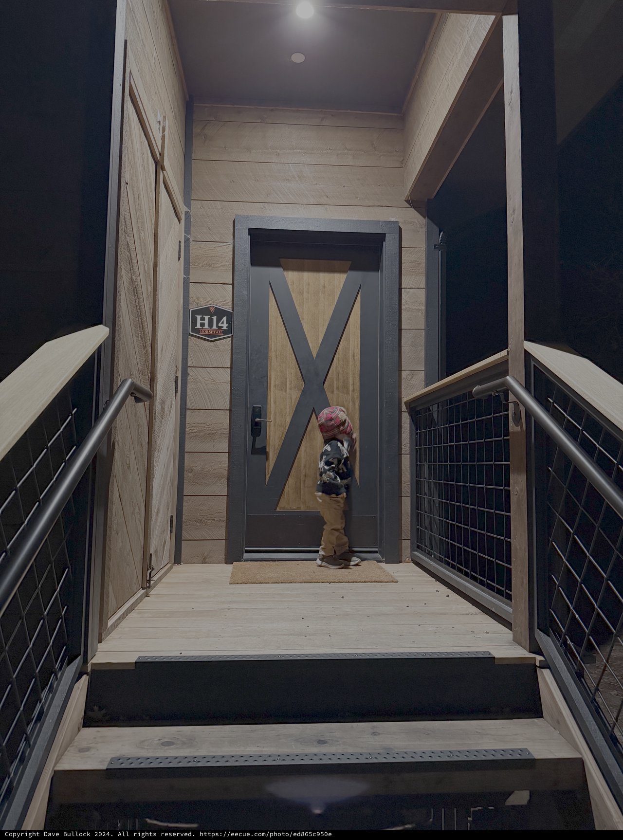 Child at Modern Mountain Lodge Entrance