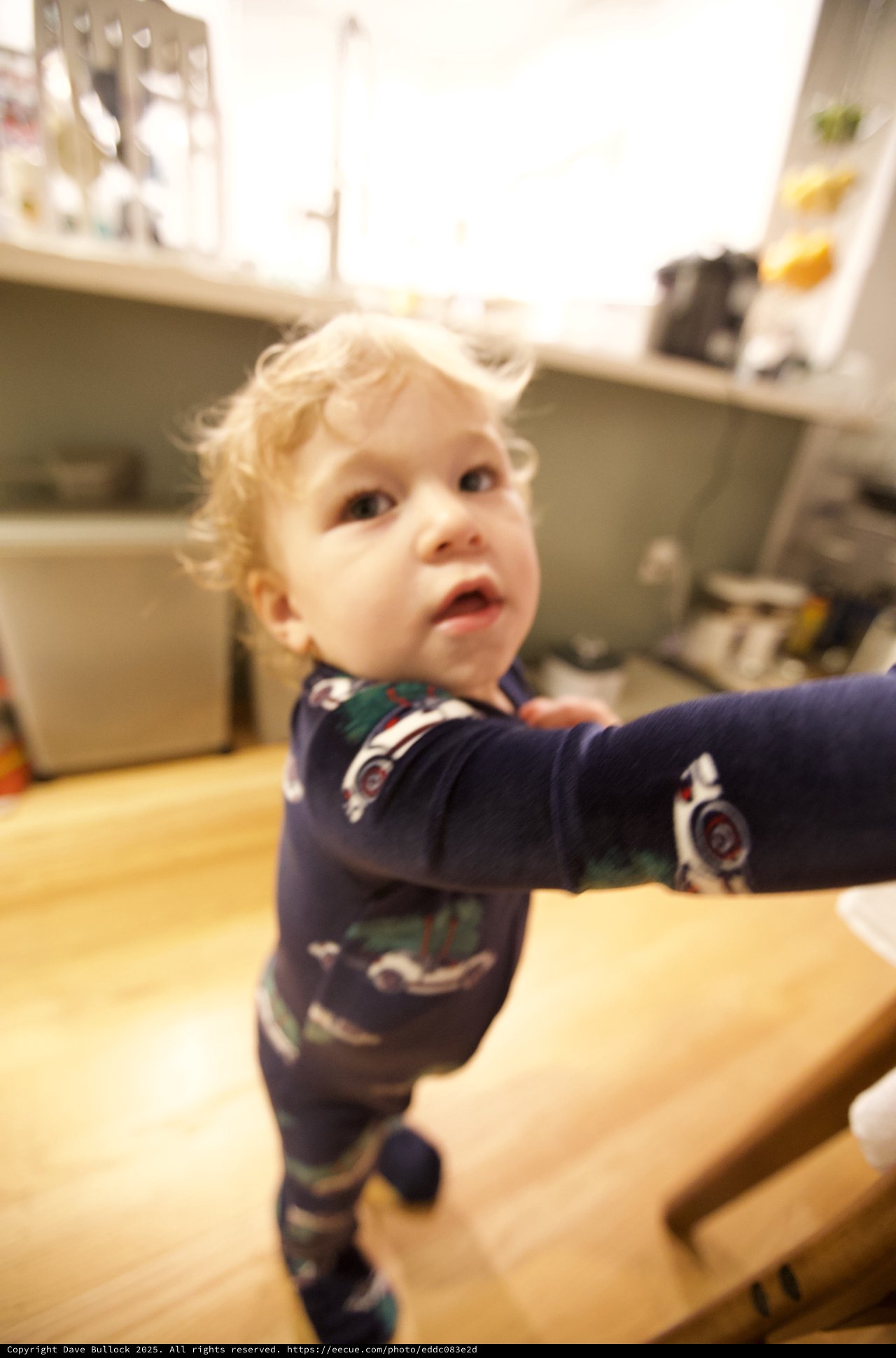 Curious Toddler in Christmas Pajamas Looking Up