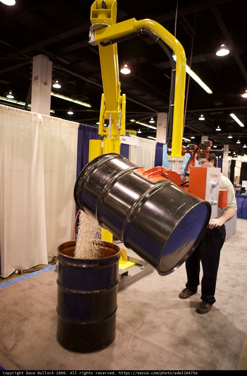 Man at a Factory with a Large Metal Barrel