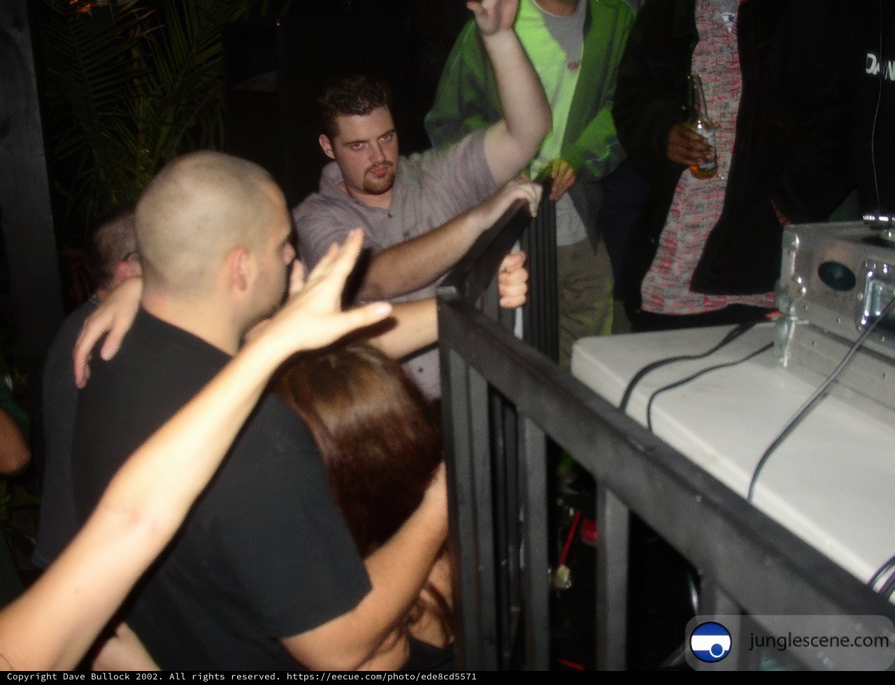 Crowd Gathers Around Kingpin Holding Woman's Hand at Night Club