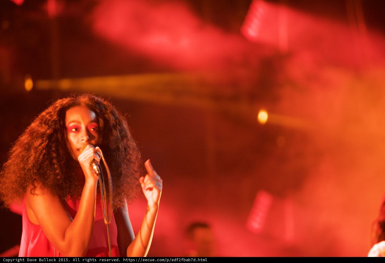 Solange Portrait Singing Finger Raised Red Orange Haze