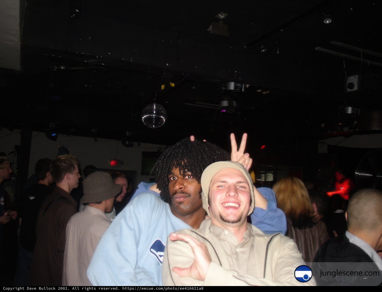 Two Men Strike a Pose at Nightclub Party