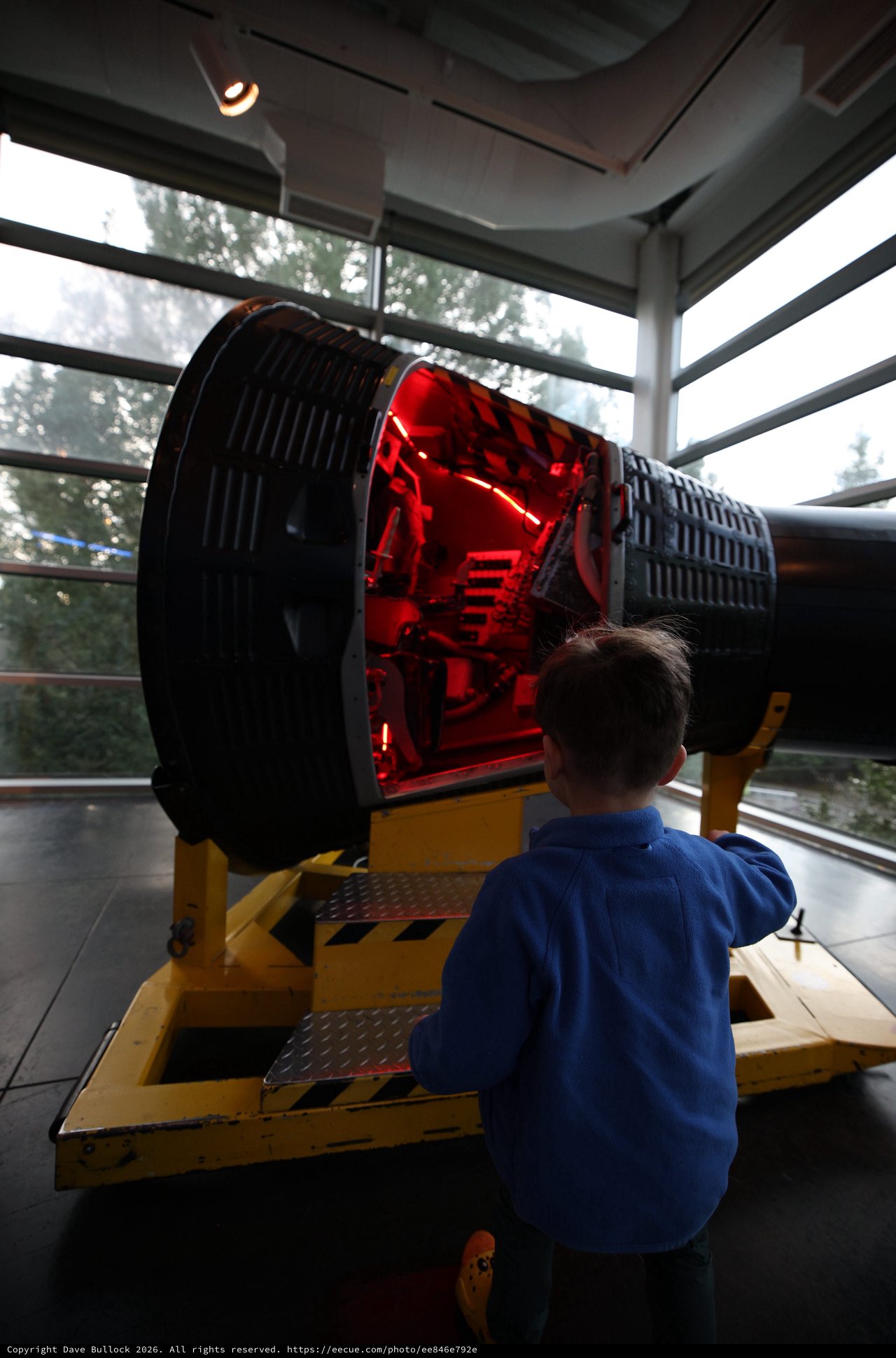 Child Observing Large Telescope Exhibit at Space Center