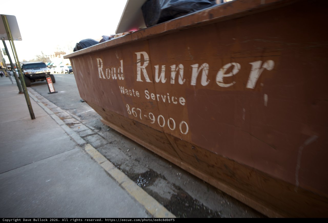 Road Runner Waste Service Dumpster on Urban Street
