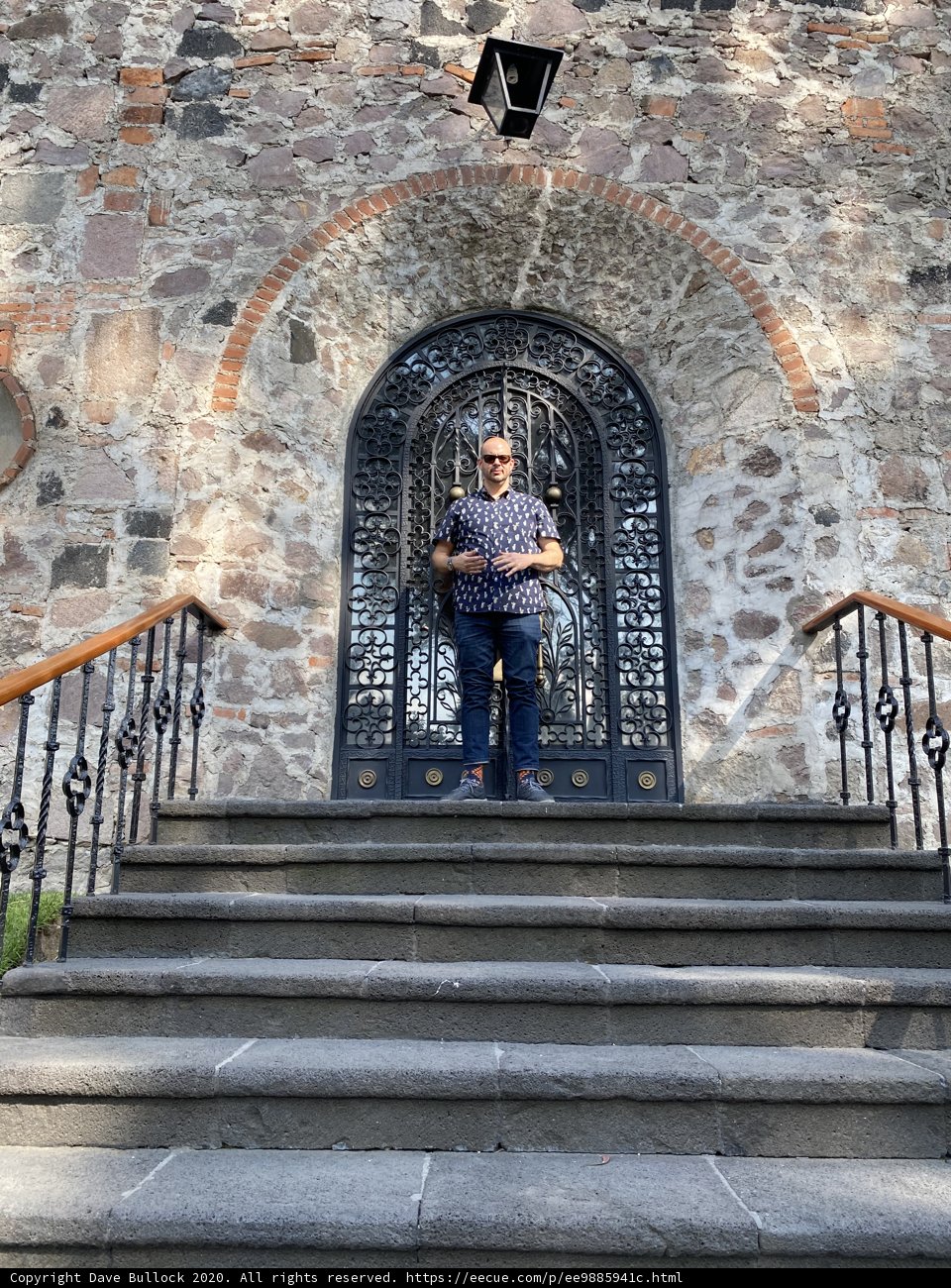 Man Standing at Stone Building Entrance