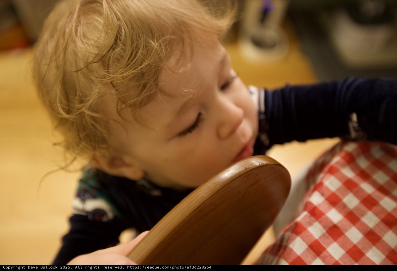 Curious Toddler Examining Wooden Bowl at Christmas
