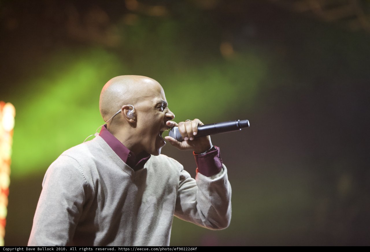 Sweater-Clad Entertainer Belts Out Hit Songs on Stage
