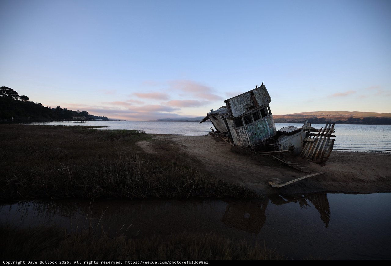 Abandoned Shipwreck at Dusk on Coastal Mudflats