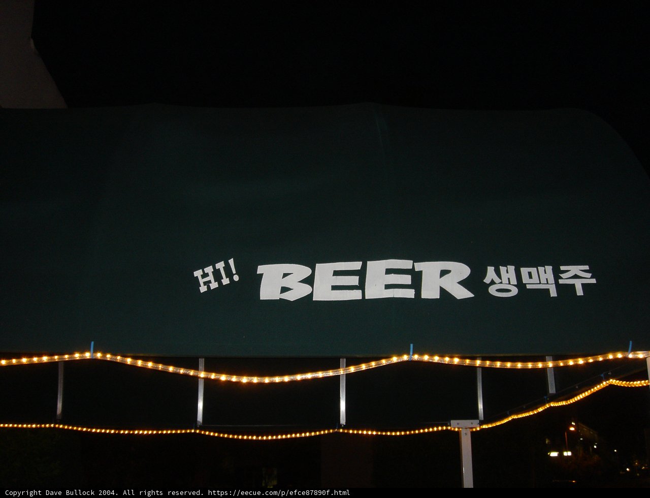 Green Canopy with Beer Sign at Night