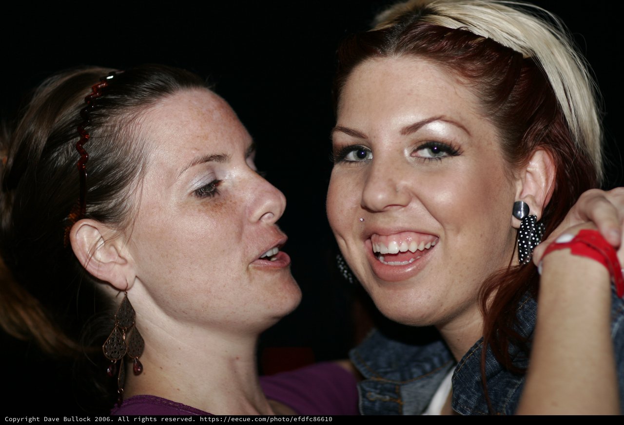 Two Friends Share a Joyful Moment at Night Event