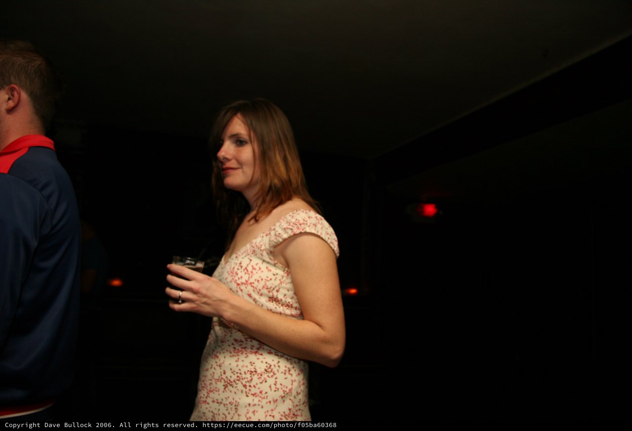 Woman in Floral Dress at Dimly Lit Venue