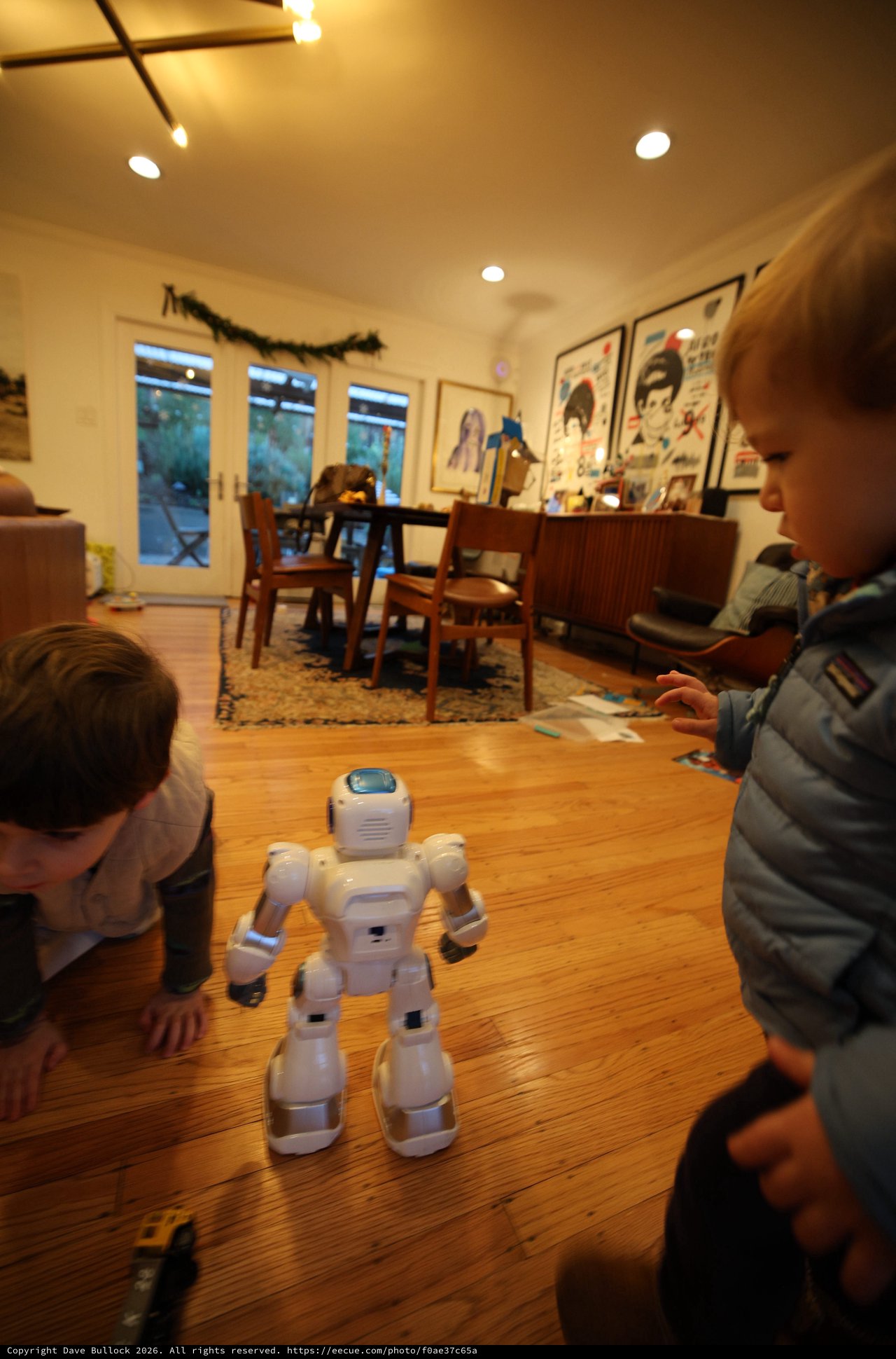 Children Watch White Humanoid Robot in Cozy Living Room