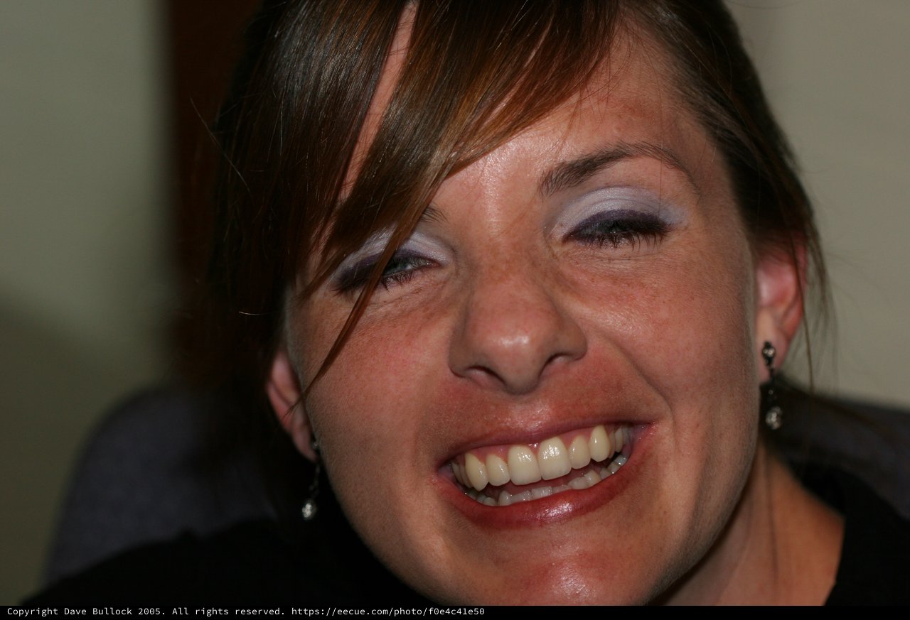 Joyful Woman Laughing at Indoor Social Gathering