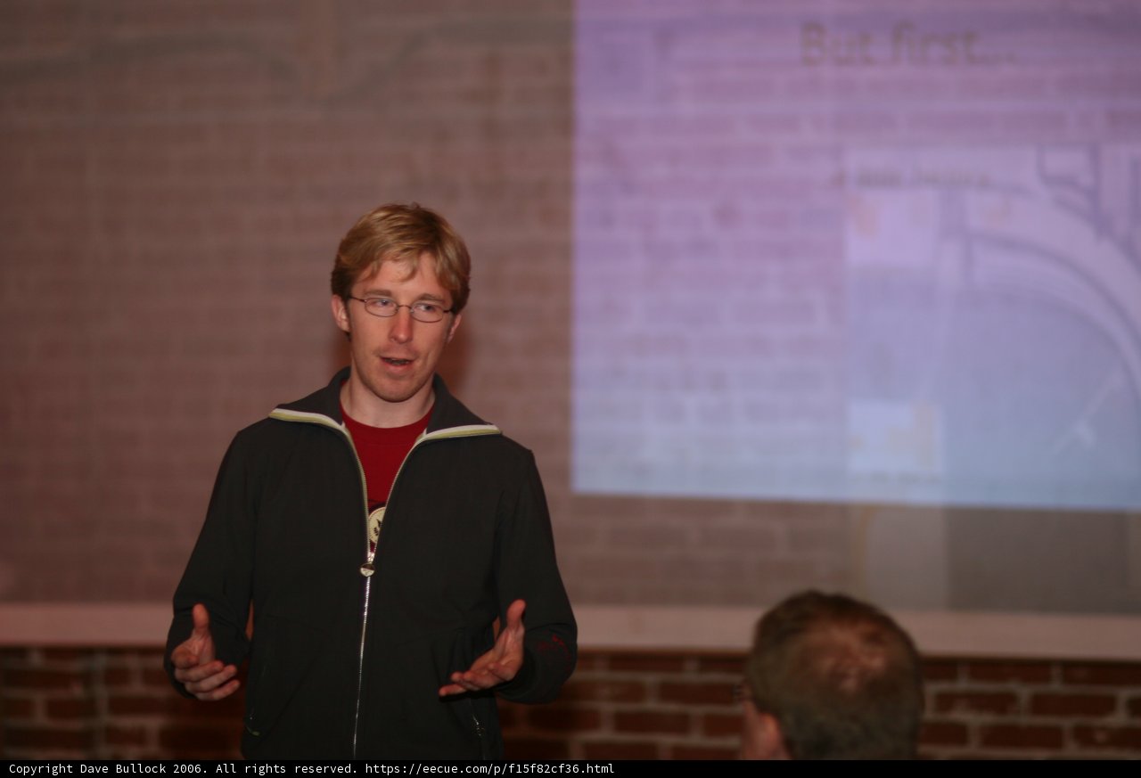 Man delivering lecture to a crowded room