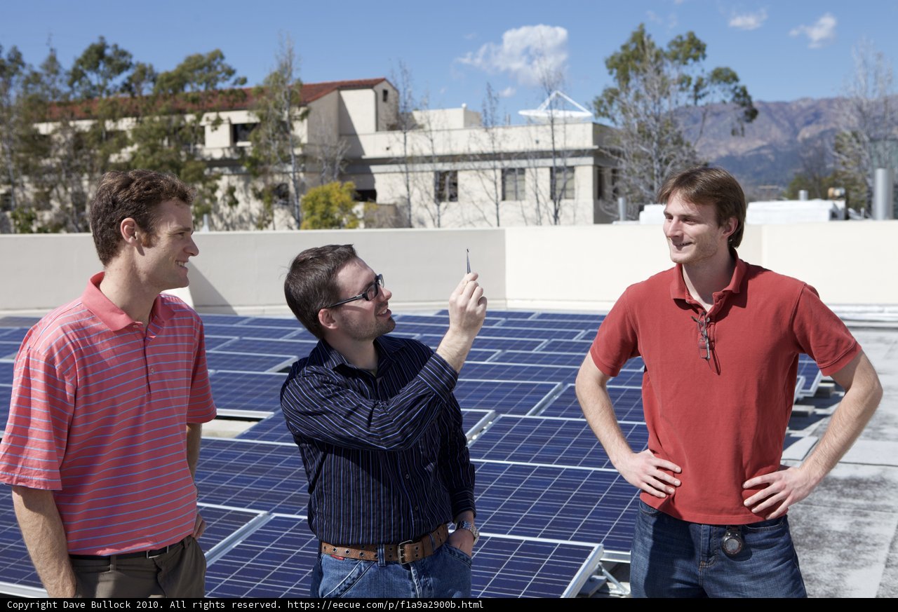Three Men Harnessing Solar Power on a Rooftop