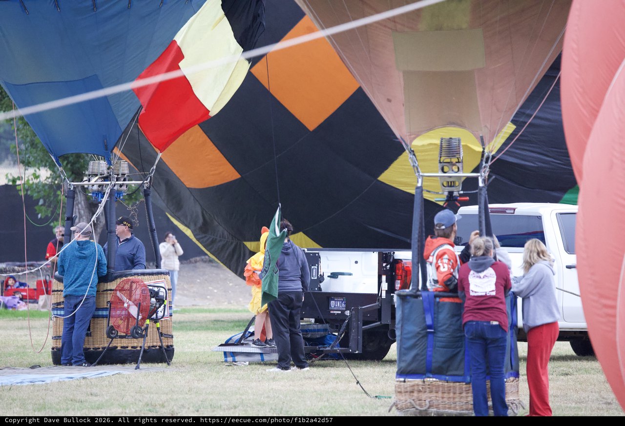Ground Crew Inflating Colorful Hot Air Balloons at Festival