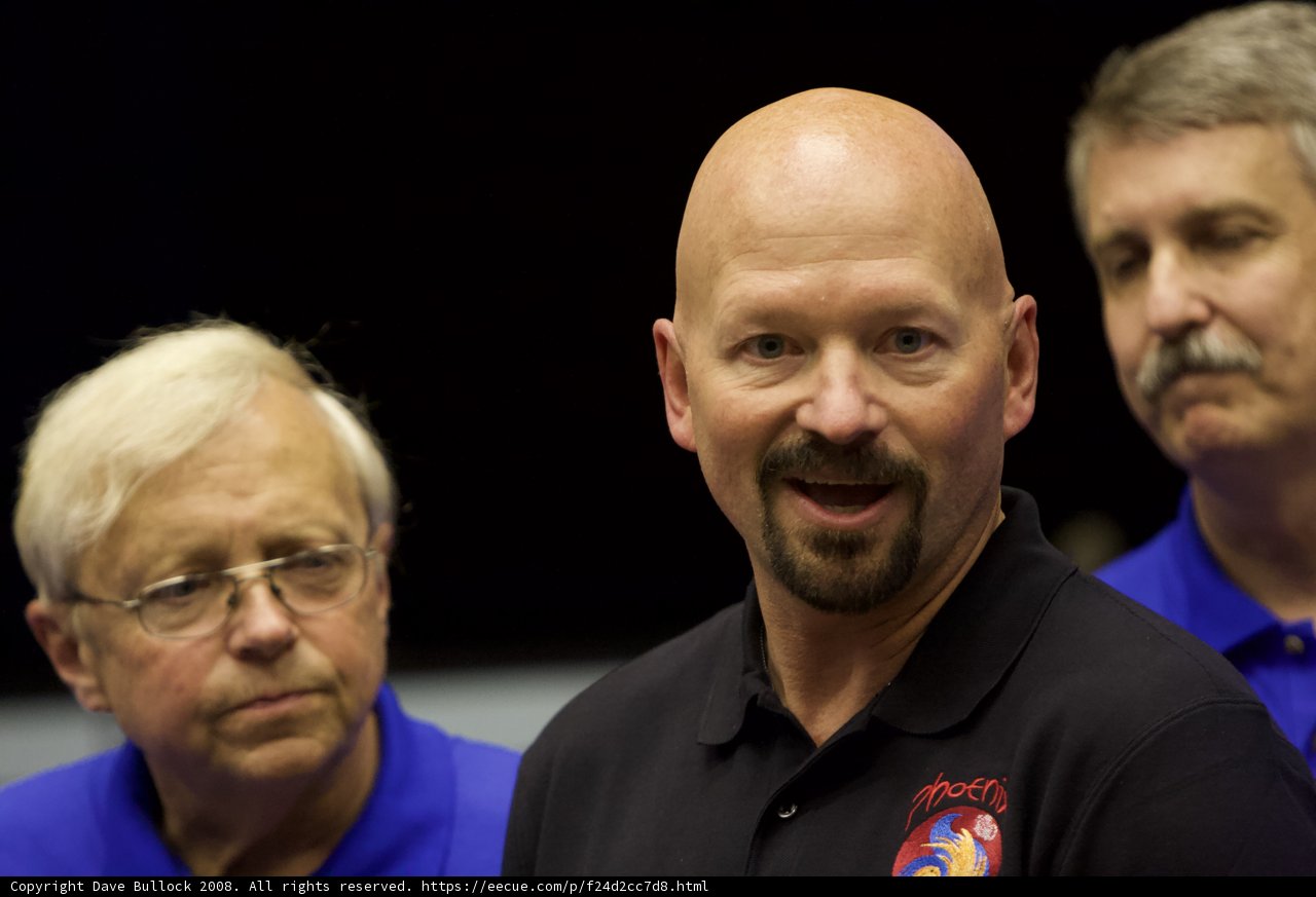 Three Men in Black Shirts and Blue Polos