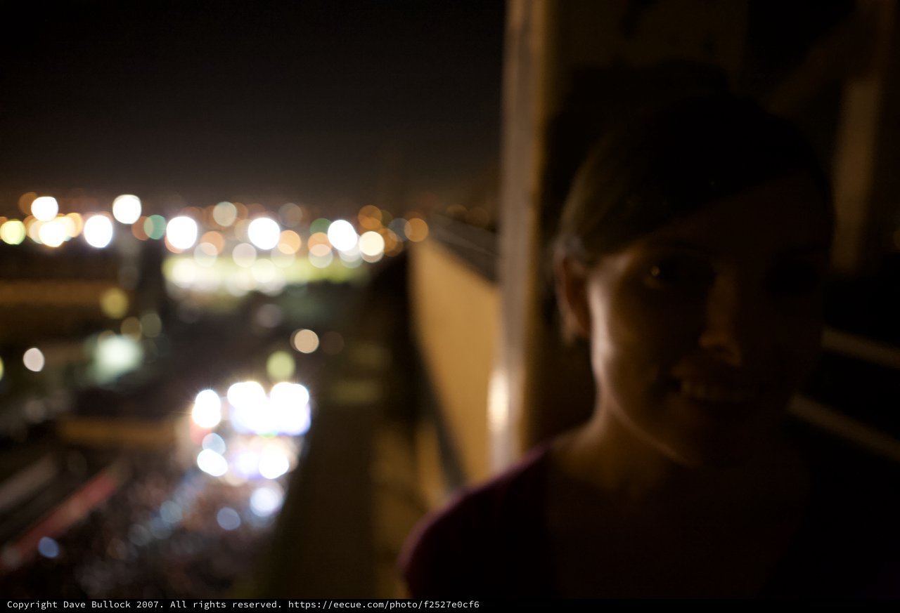 Silhouette Gazing at City Lights from Festival Balcony