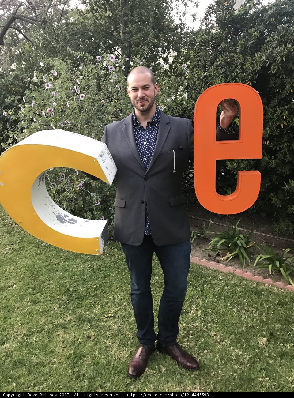 Dave B Holding Up the Letter D Outdoors
