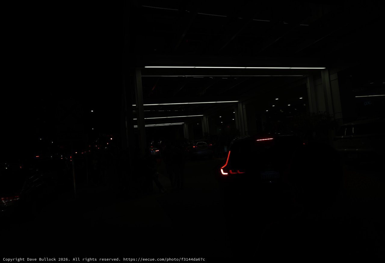 Red Taillights Glow in Dark Parking Structure Night