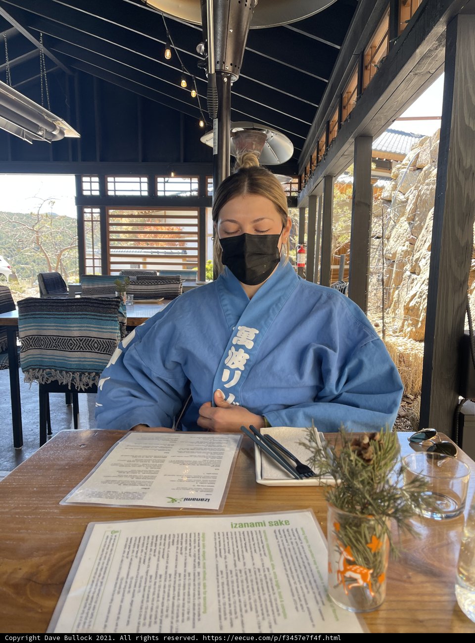 Masked Woman at Table with Flower Arrangement