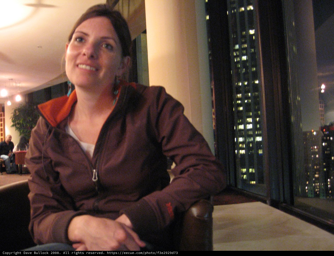 City Lights Glow Behind Smiling Woman at Night