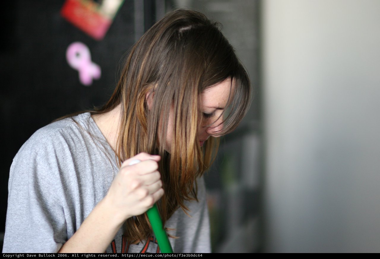 Young Woman Sweeping with Head Bowed Down