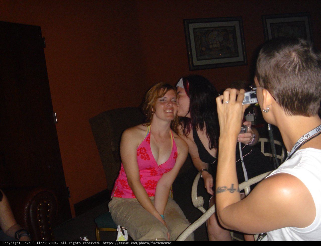 Friends Sharing a Playful Kiss at DEF CON Party