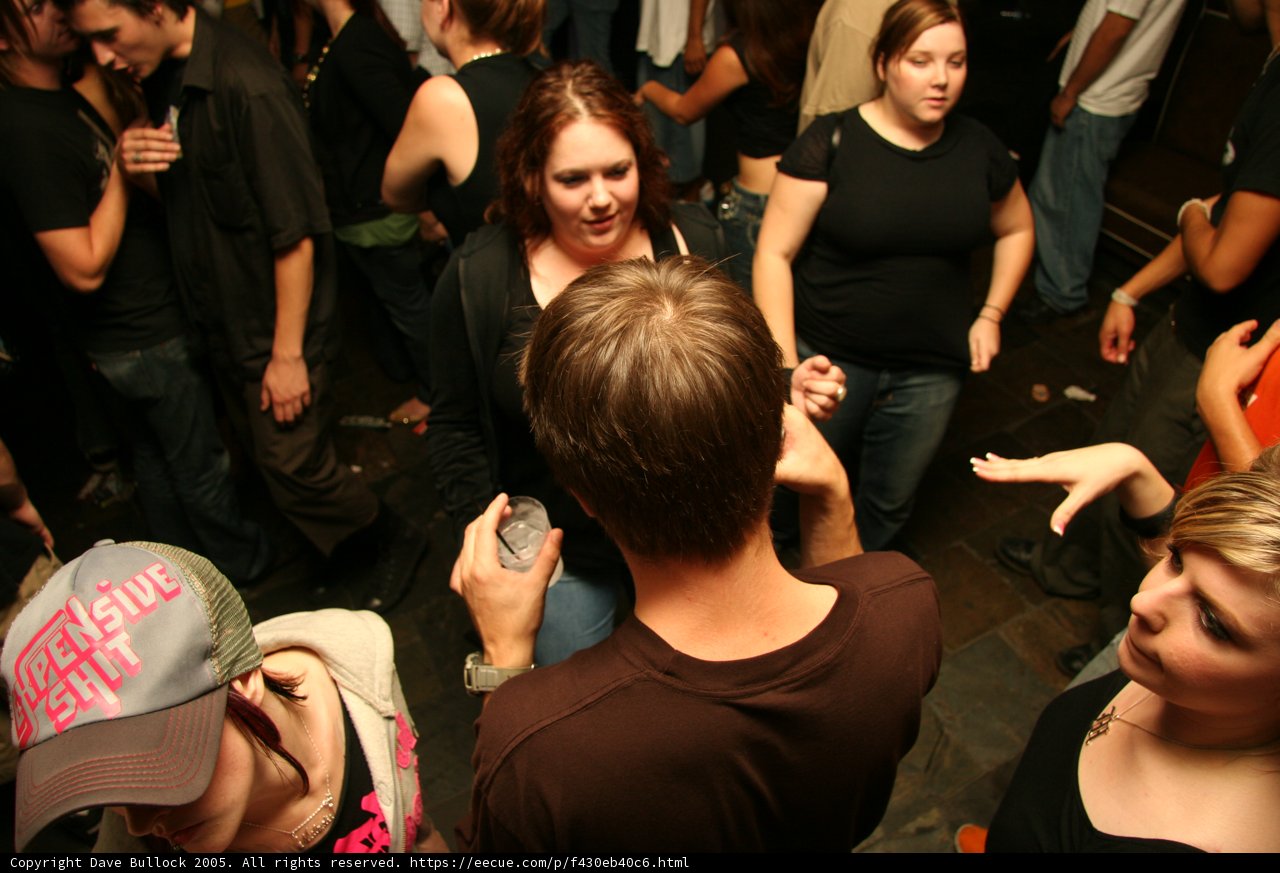Black Shirted Man in Baseball Cap at Night Club