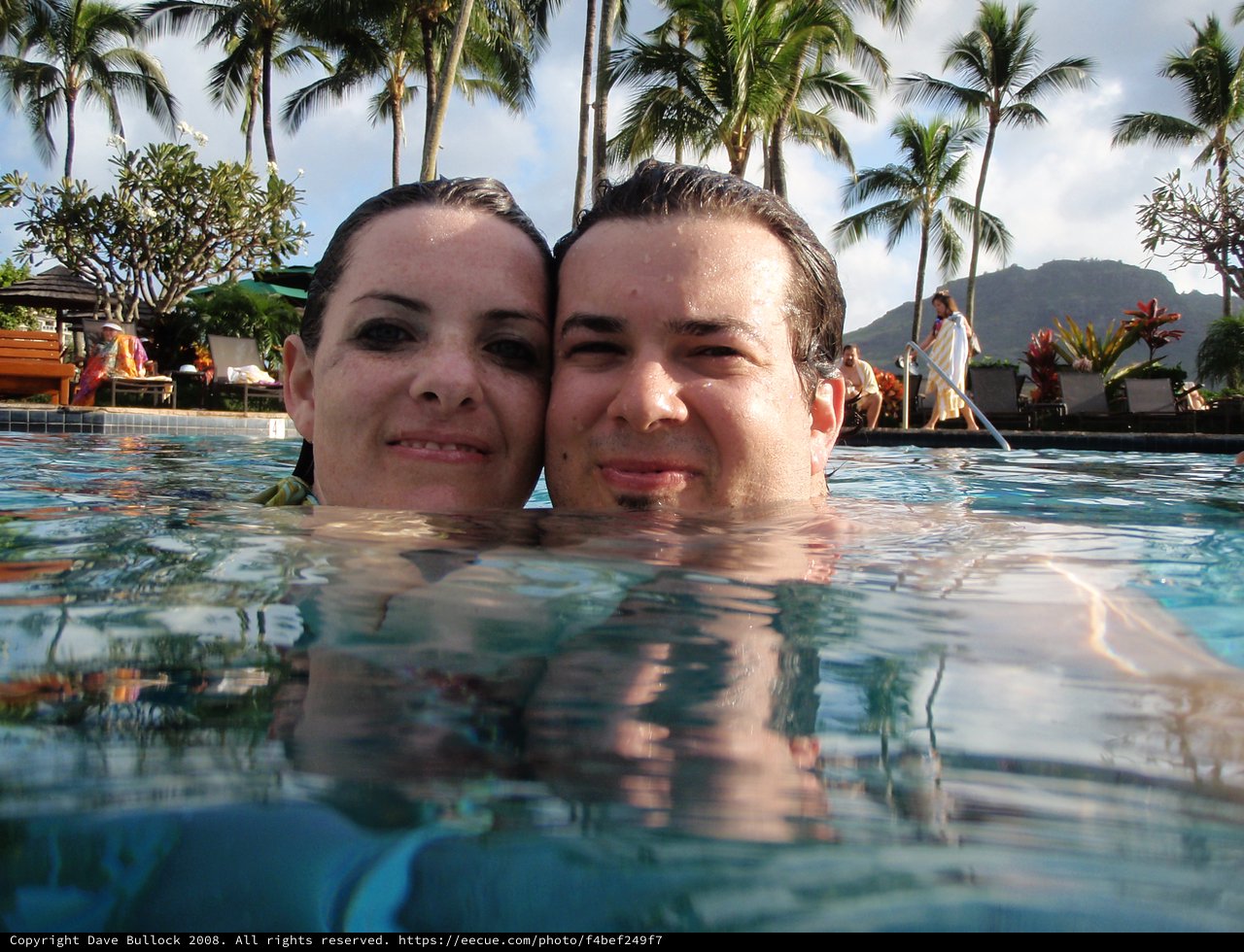 Couple Posing at Water Level in Tropical Pool