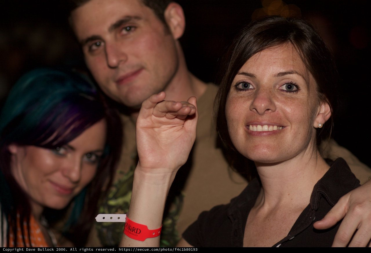 Three Friends Smiling at a Nighttime Social Event