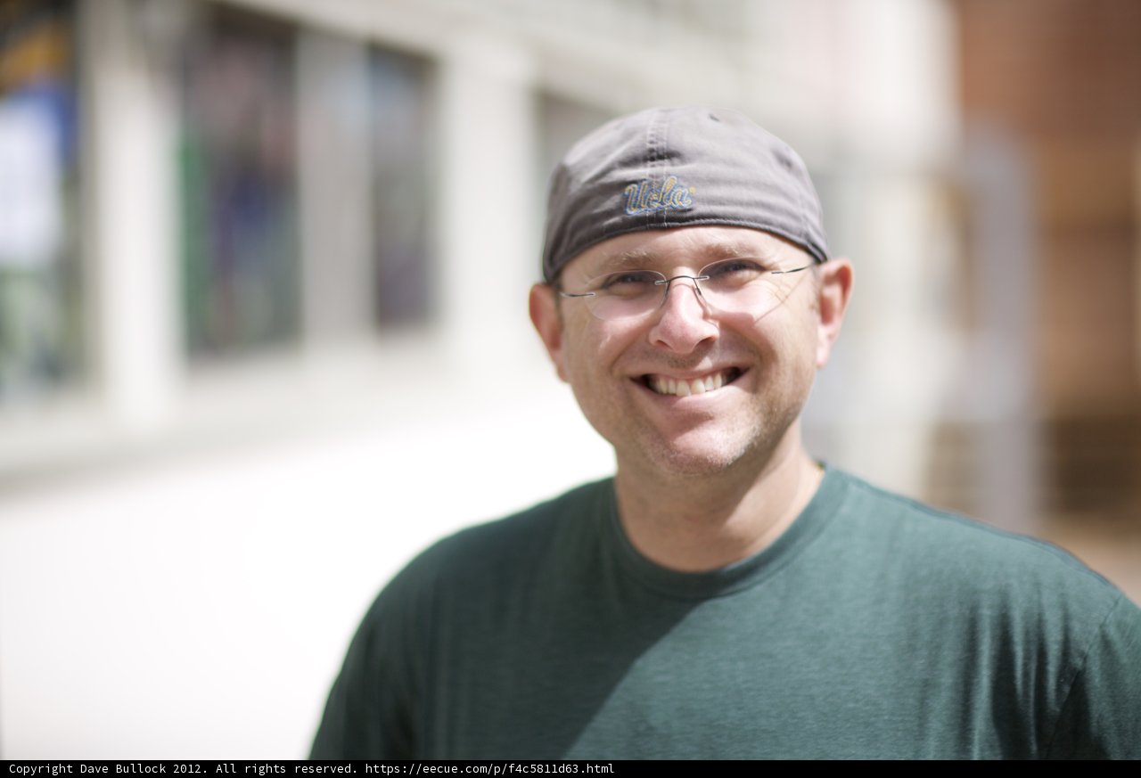 Smiling Man in Cap and Glasses