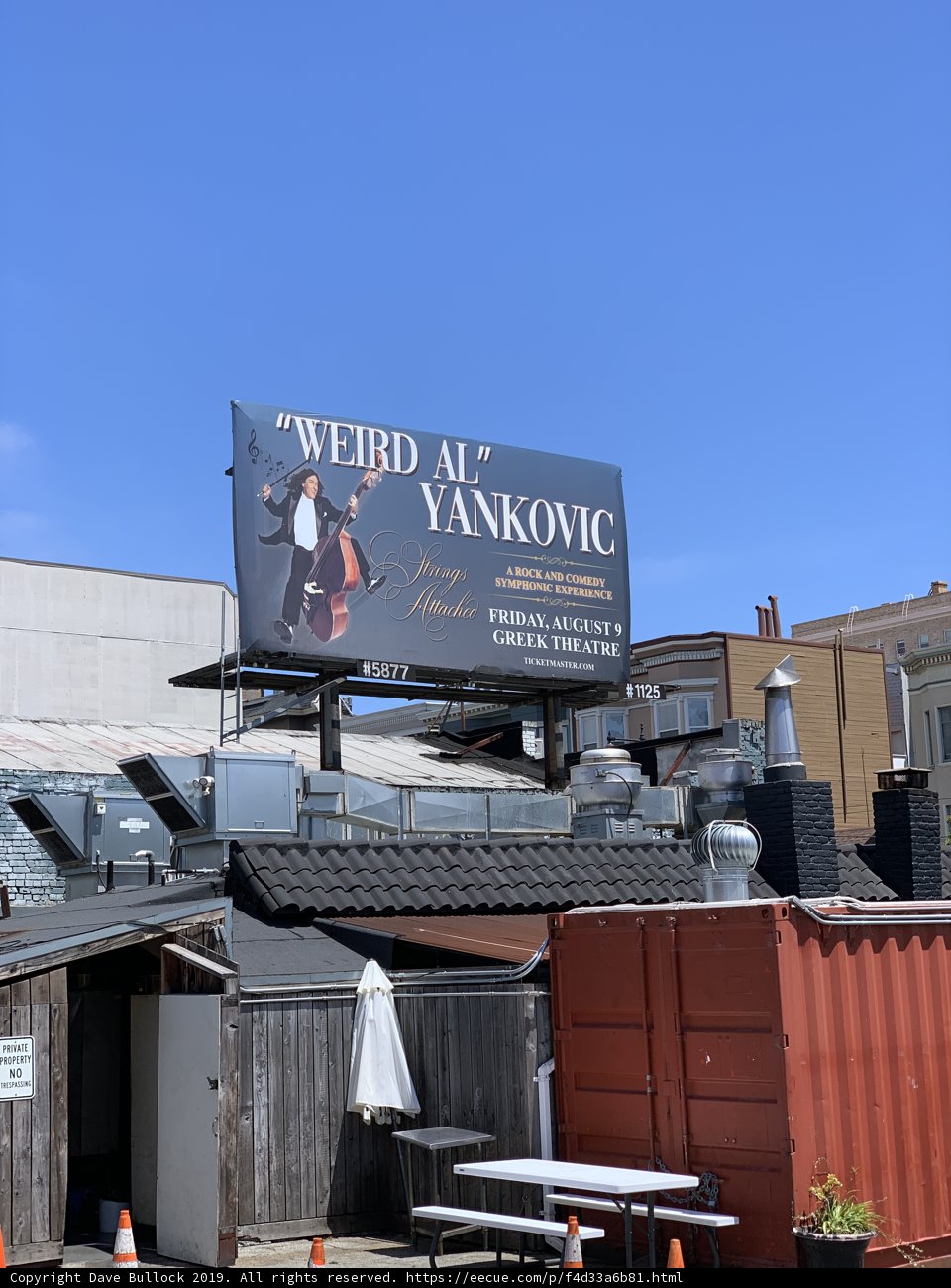 Weird Al Yankovic poses in front of "Weby Al Vanko" billboard on San Francisco rooftop