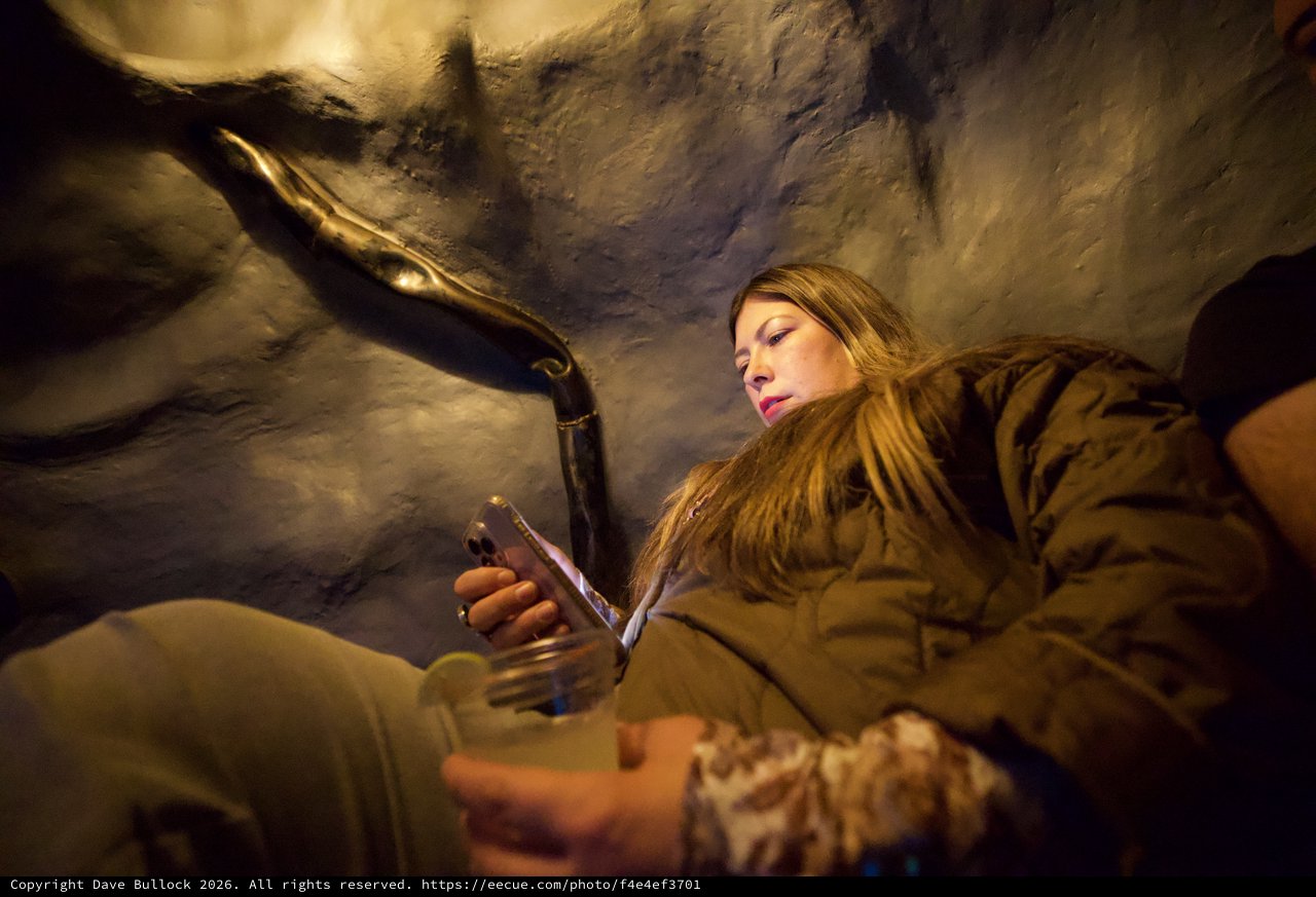 Woman Examining Mammoth Replica in Museum Cave Setting
