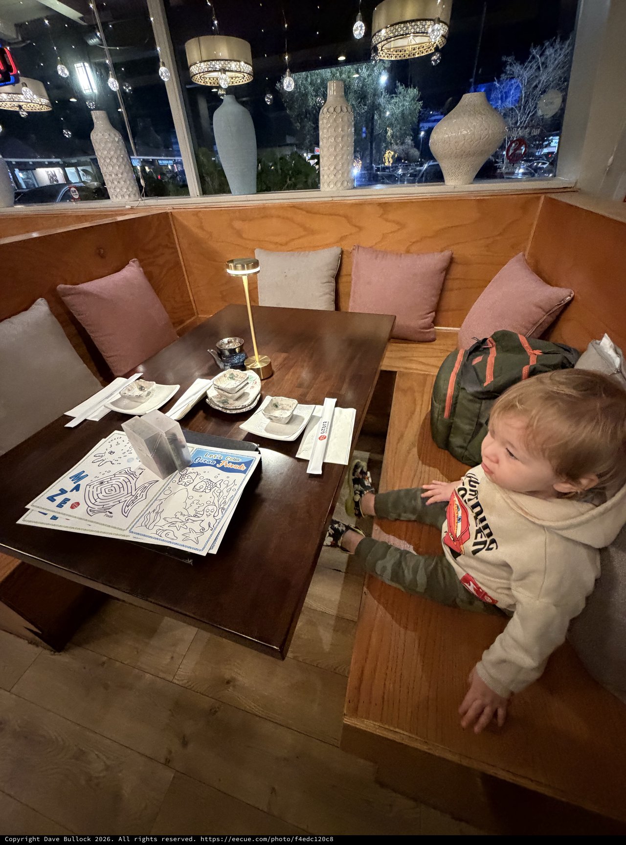 Toddler Exploring Restaurant Booth at Night