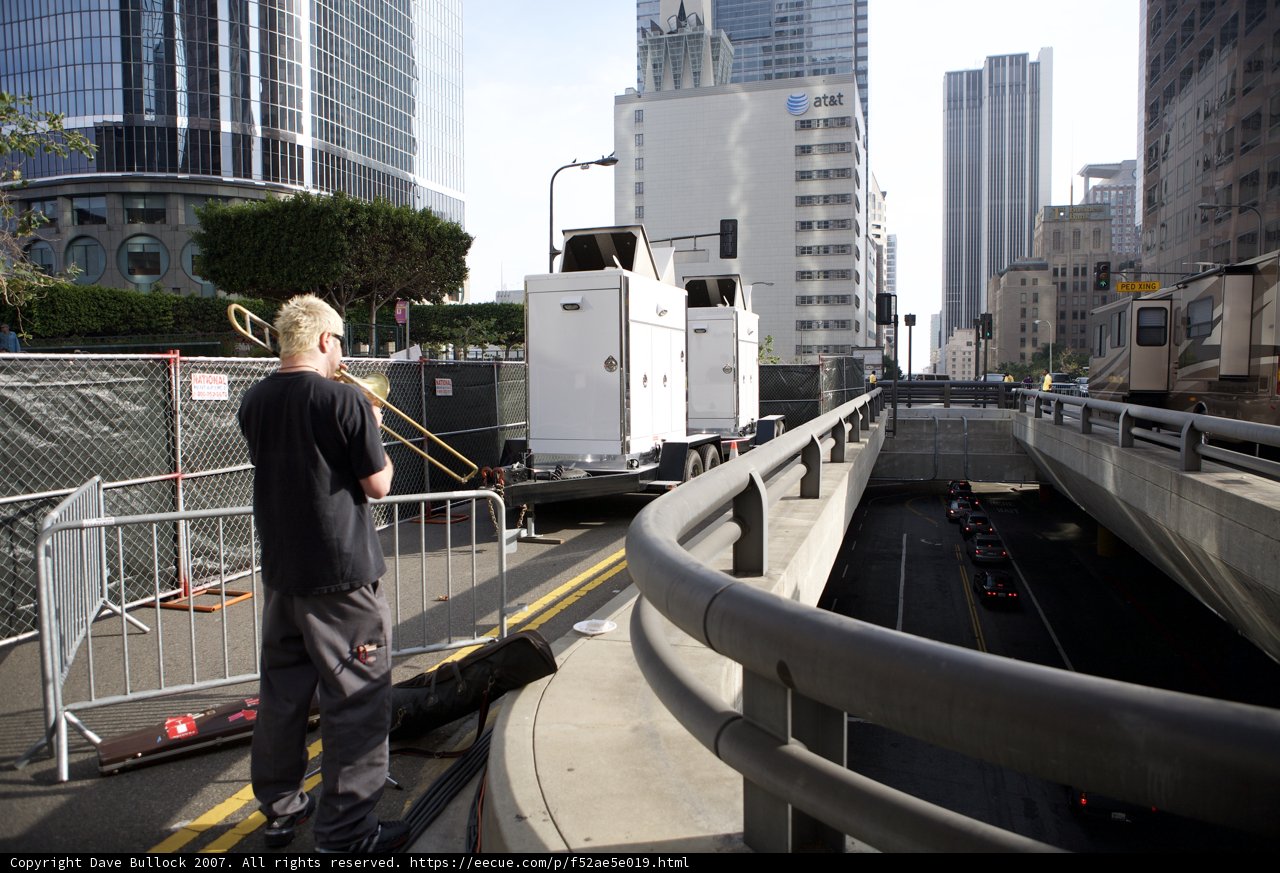 Man on Bridge Observing Truck Below