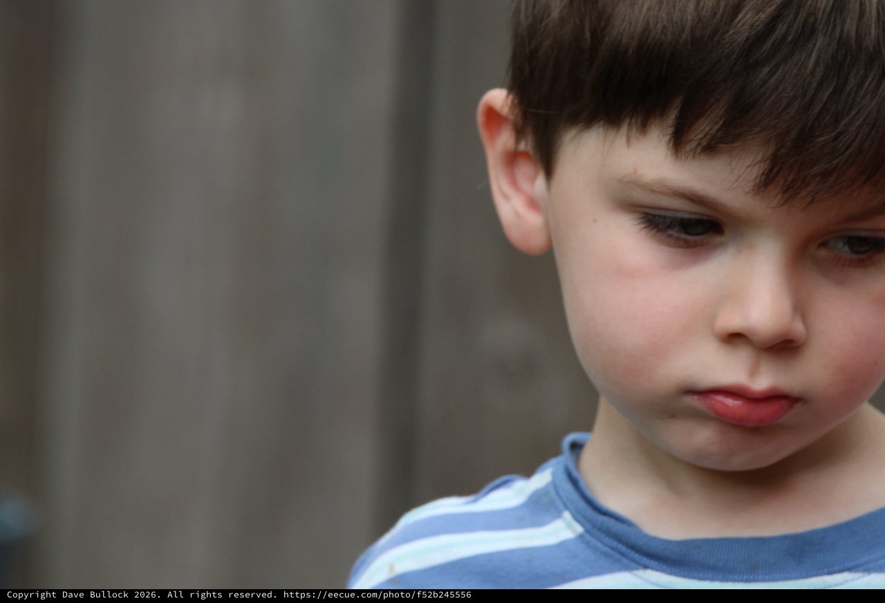 Contemplative Young Boy in Blue Striped Shirt