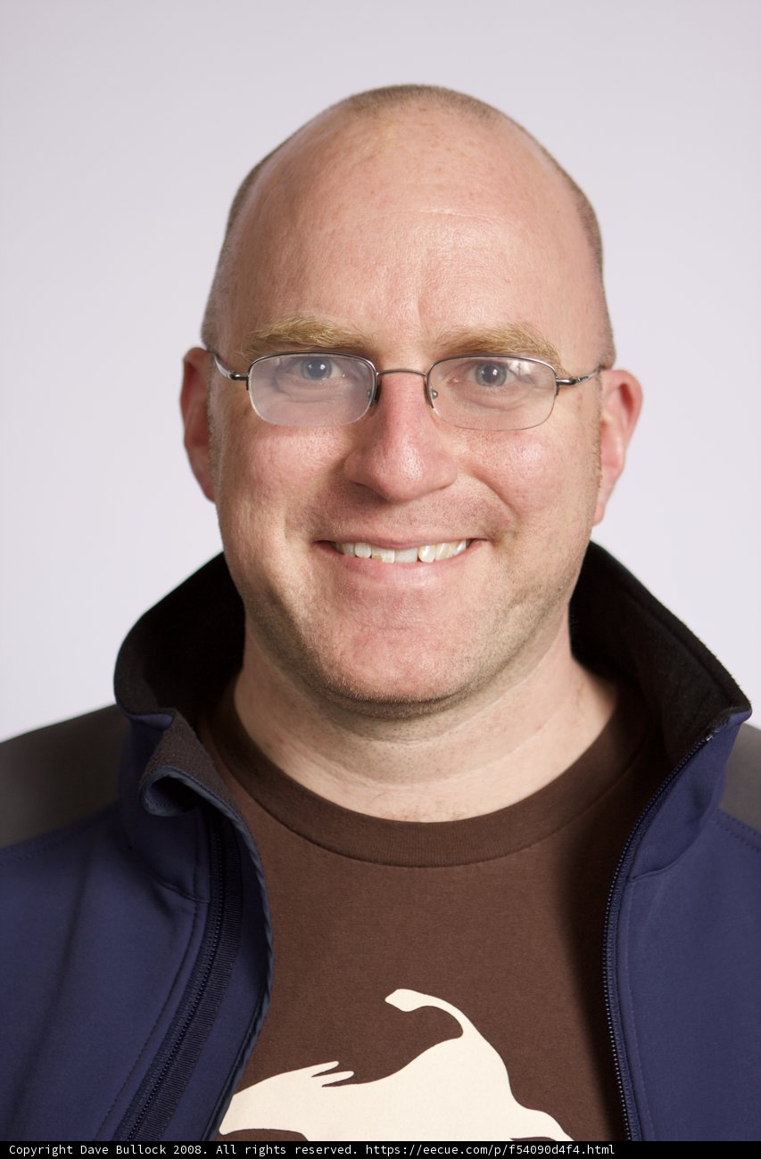 Smiling Man in Blue Jacket and Glasses