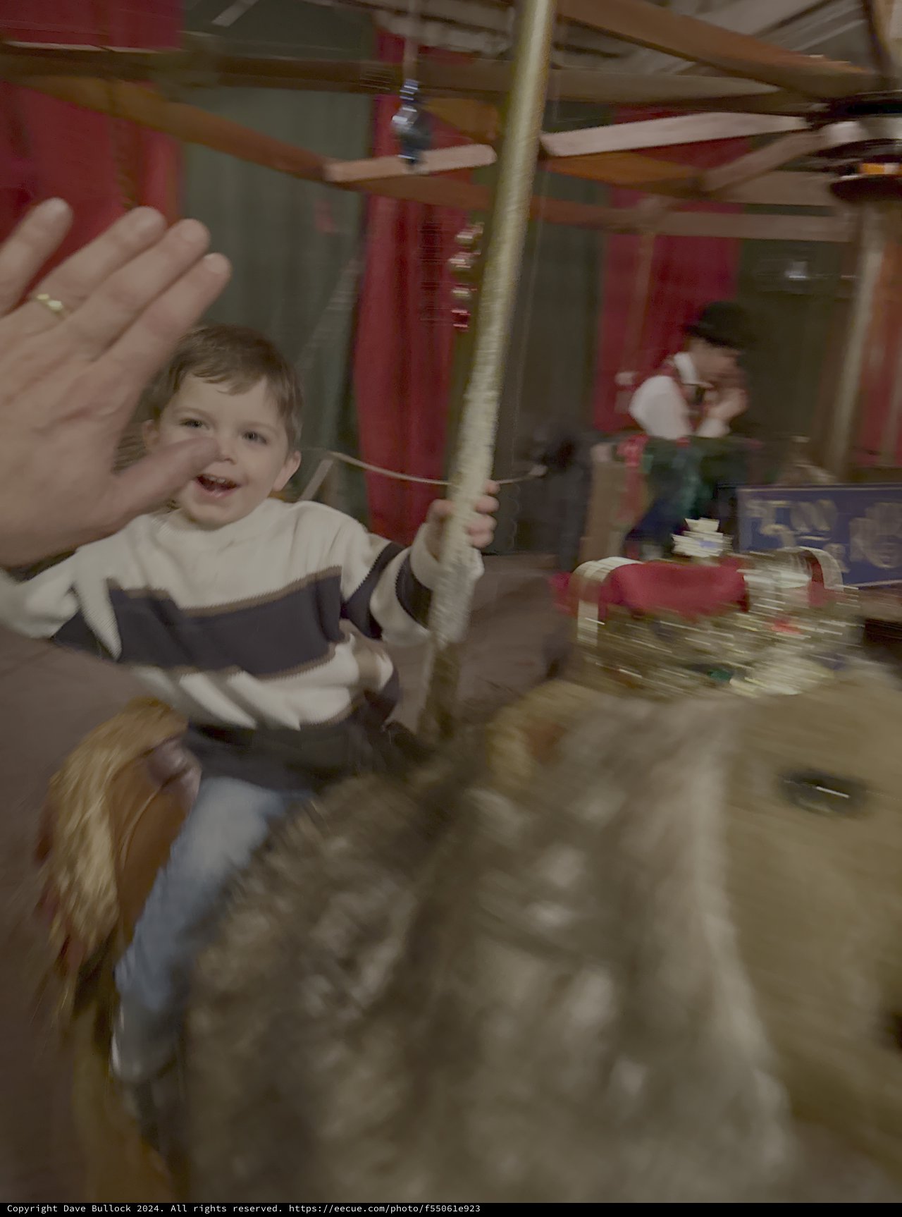 Joyful Child Waving on Carousel Horse