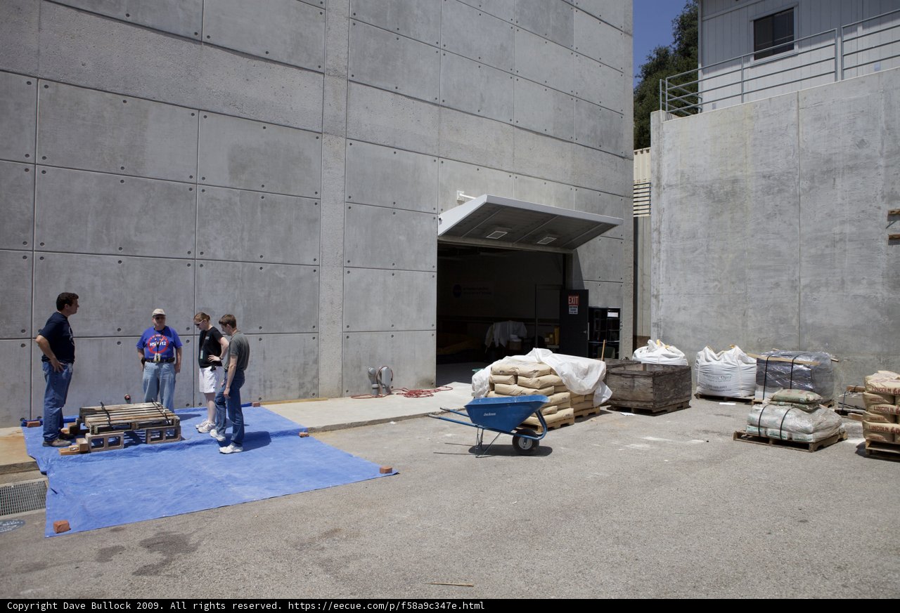 Group of People Outside Plywood Building