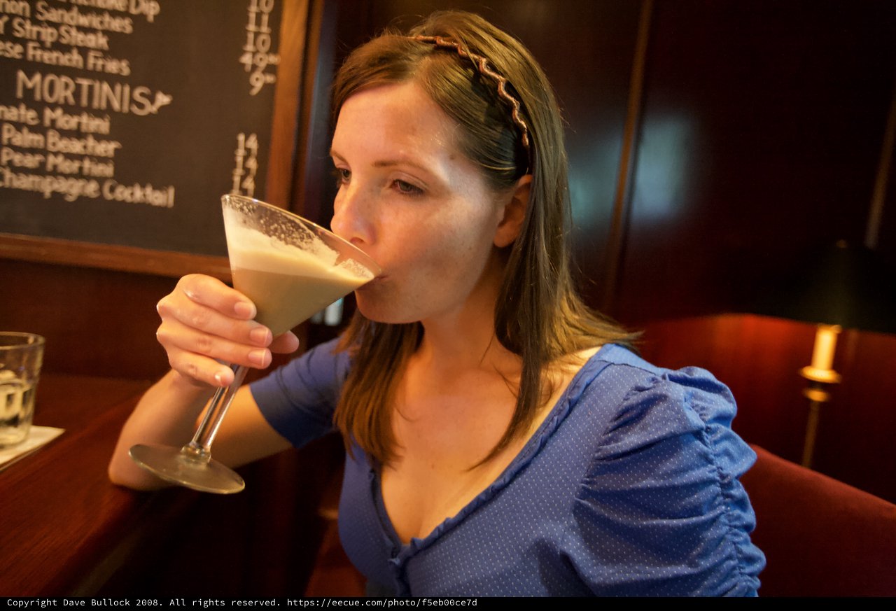 Woman Savoring a Creamy Martini at Upscale Bar
