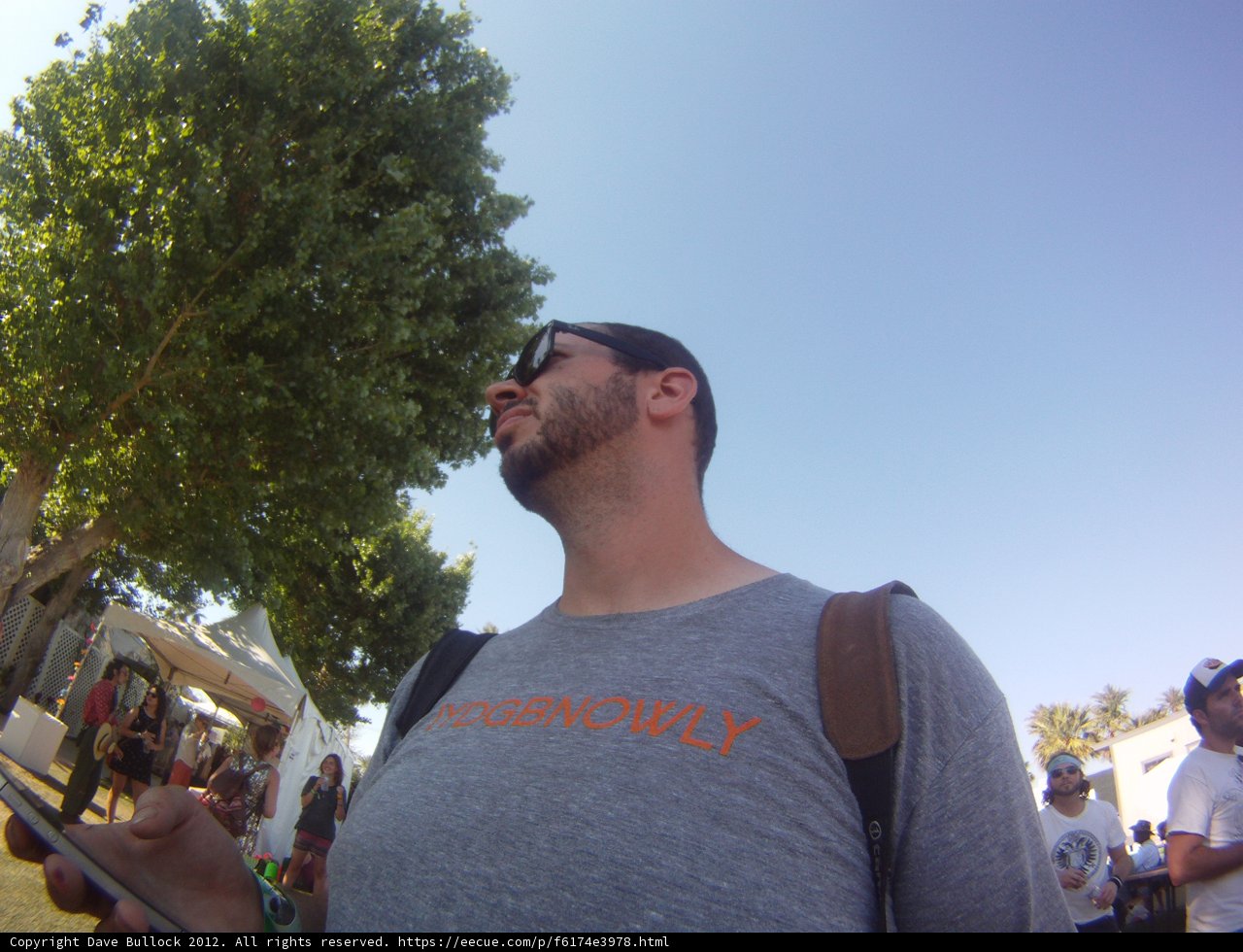 Gray Shirted Man in a Baseball Cap Surrounded by a Crowd