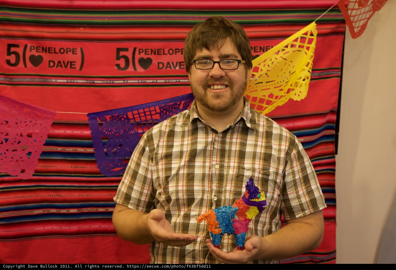 Man Proudly Holds Mini Piñata at Fiesta Anniversary Party