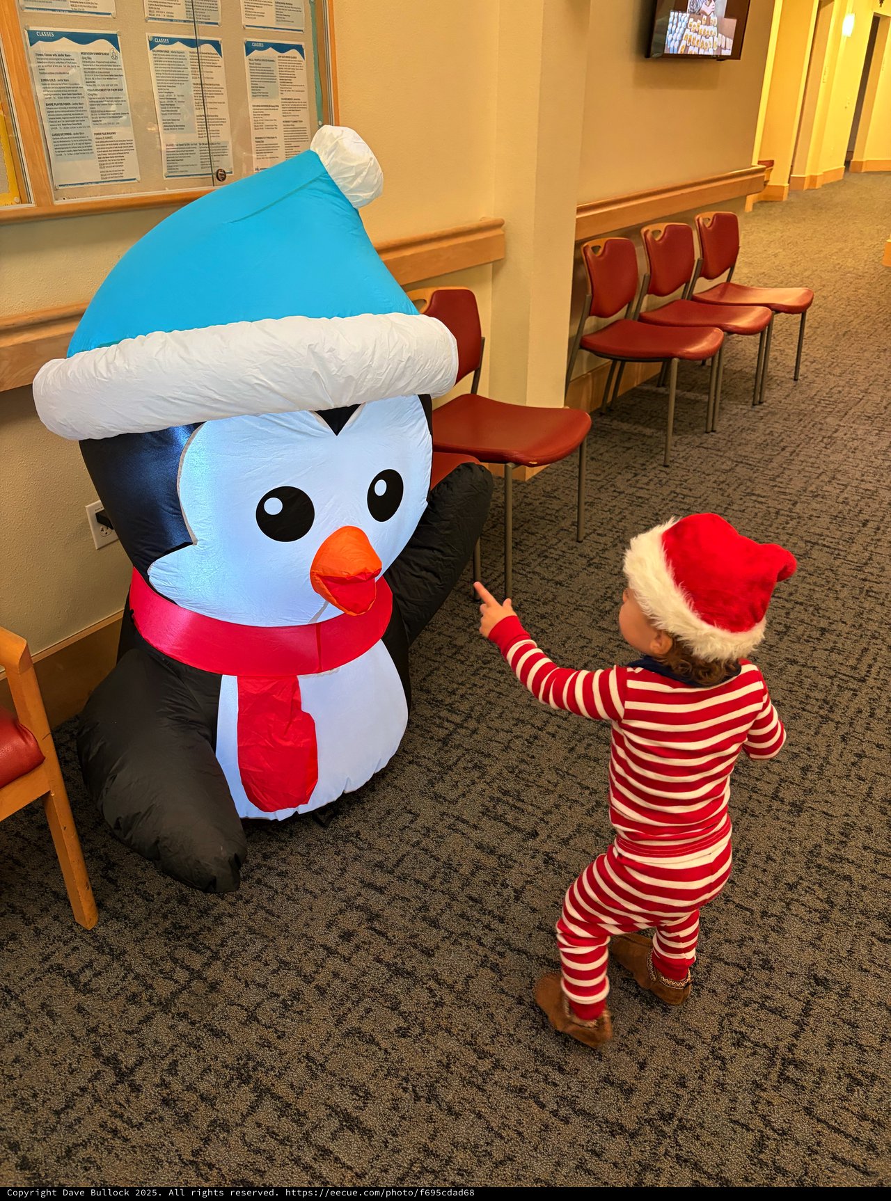 Child Meets Inflatable Snowman in Festive Holiday Setting