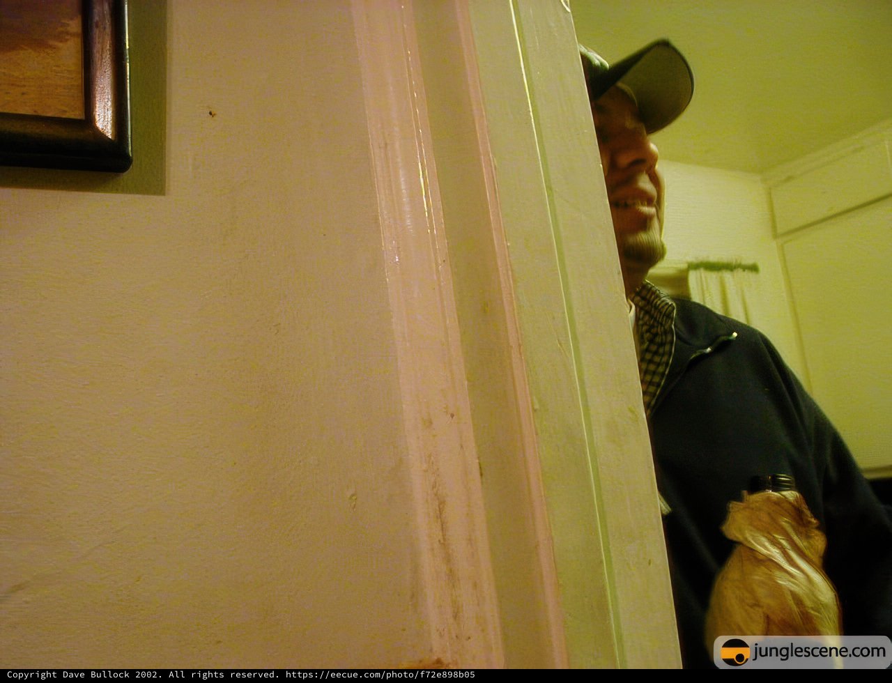 Man in a Hat Standing in Doorway
