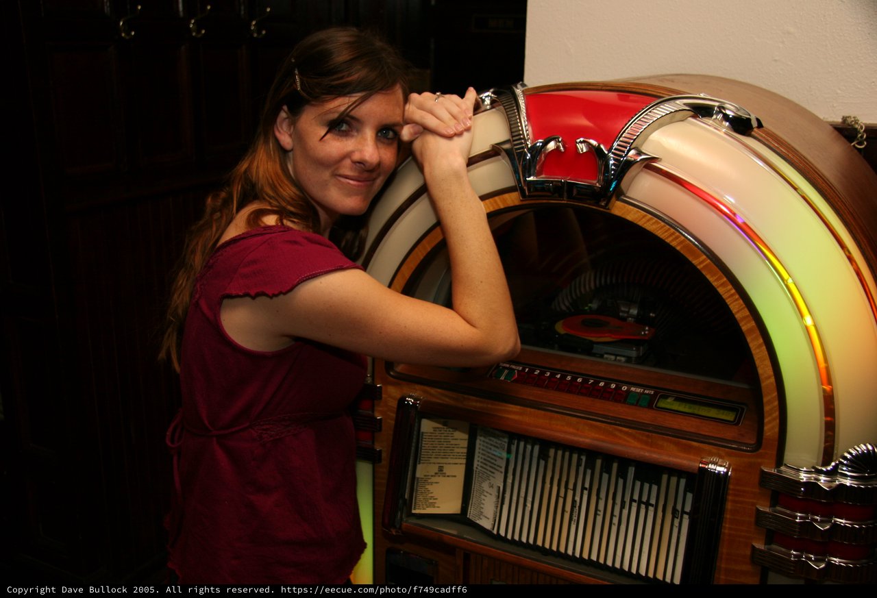 Retro Charm: Woman Poses with Classic Jukebox