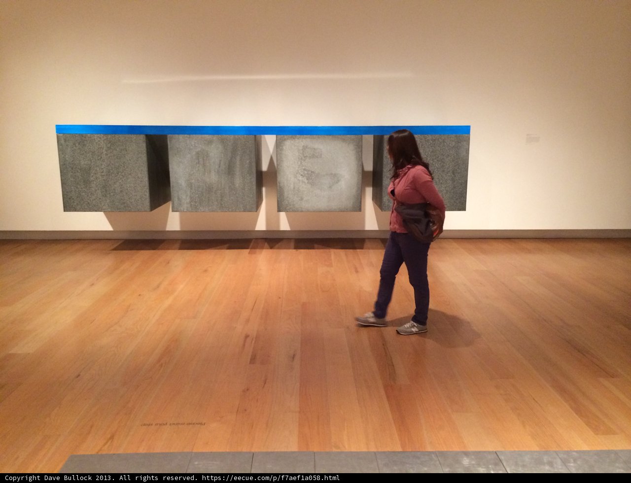 A Woman Admiring Hardwood Flooring and Modern Art