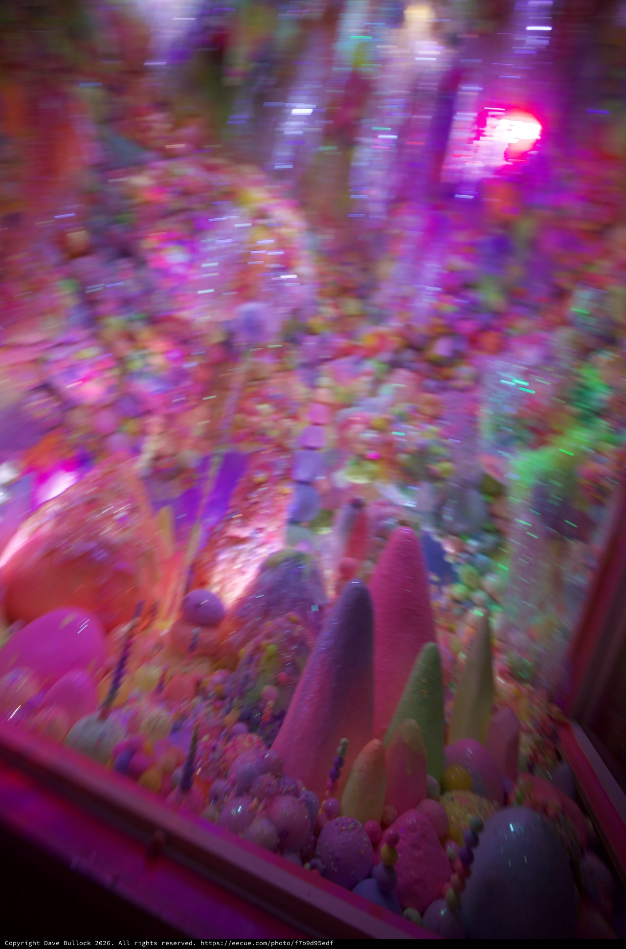 Motion Blur Through Neon-Lit Arcade Claw Machine